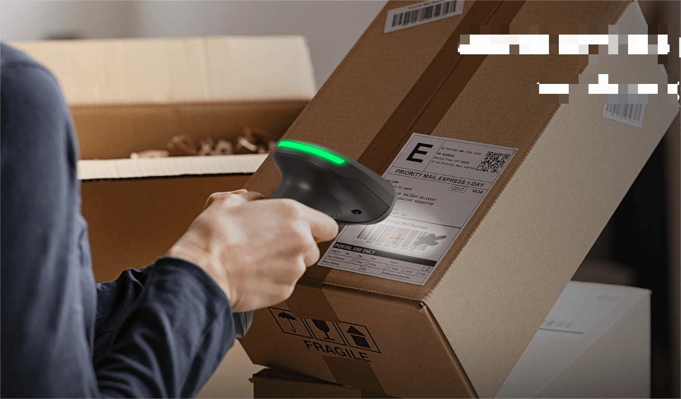 A person scanning a shipping label on a box.